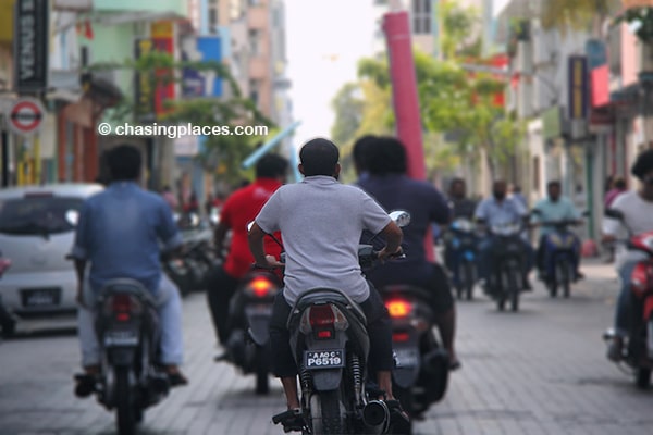 Local Maldivians driving along the narrow streets of Male.