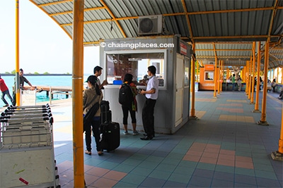 Proceed to the ferry ticket counter outside the airport