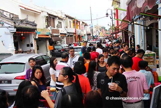 Cars squeezing through the Jonker Walk's tourist crowd
