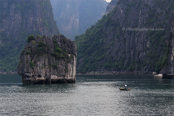 A local fisherman near a limestone outcropping in Halong Bay