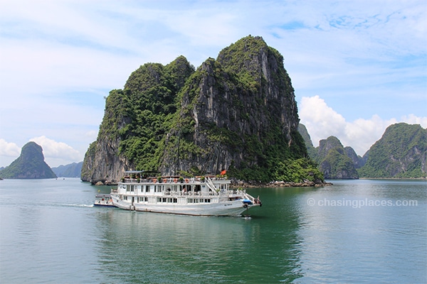 A tour boat slowly navigating through Halong Bay.jpg