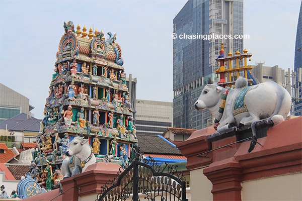 Sri Mariamman Temple designs in the foreground and urban skycrapers in the background.