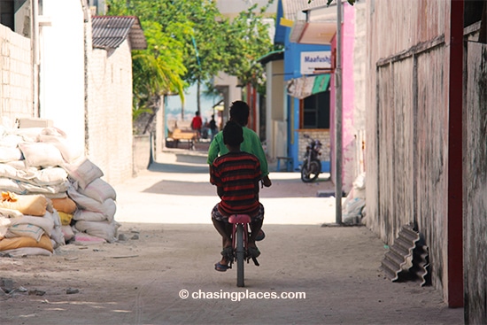 A couple of the young-Maldivian locals briskly cycling along the sandy road