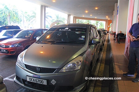 The taxis at Kota Bharu Airport are grey and located directly outside the exit